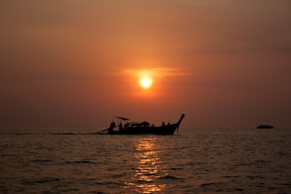 Sunset view from the boat with warm orange hues reflecting on calm sea waters.