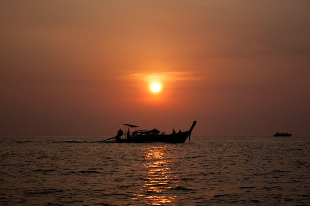 Sunset view from the boat with warm orange hues reflecting on calm sea waters.