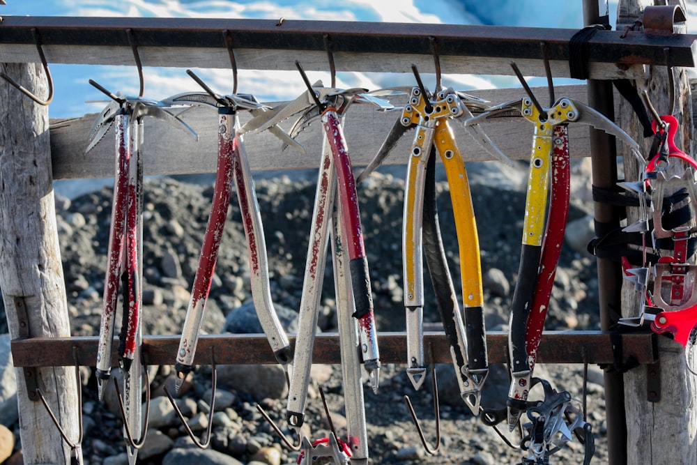 a bunch of skis hanging from a wooden fence