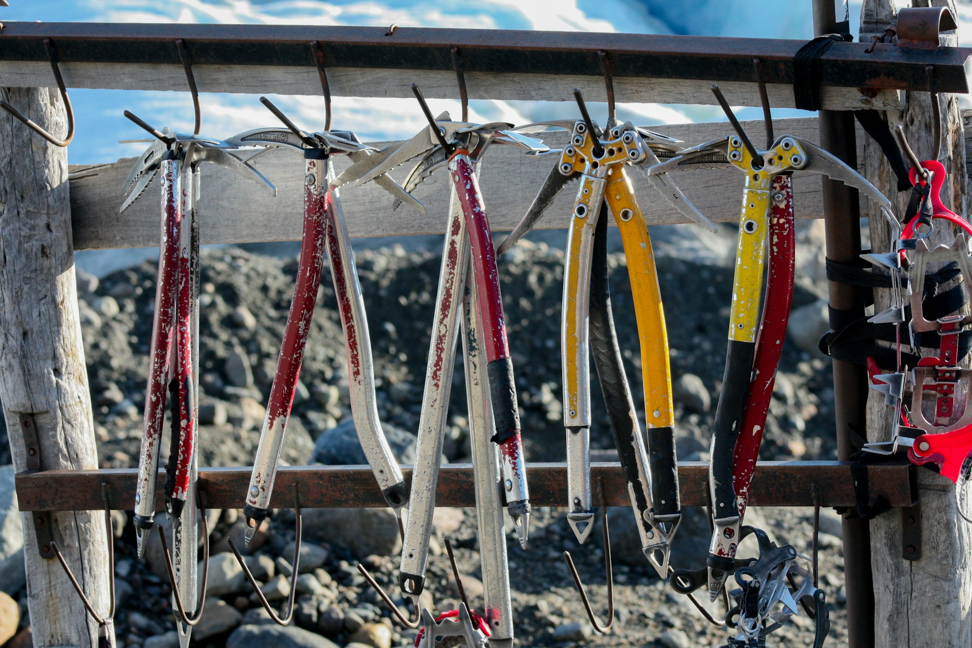 A rugged climber gripping a sturdy ice axe against a snowy mountain backdrop, showcasing durable mountaineering gear.