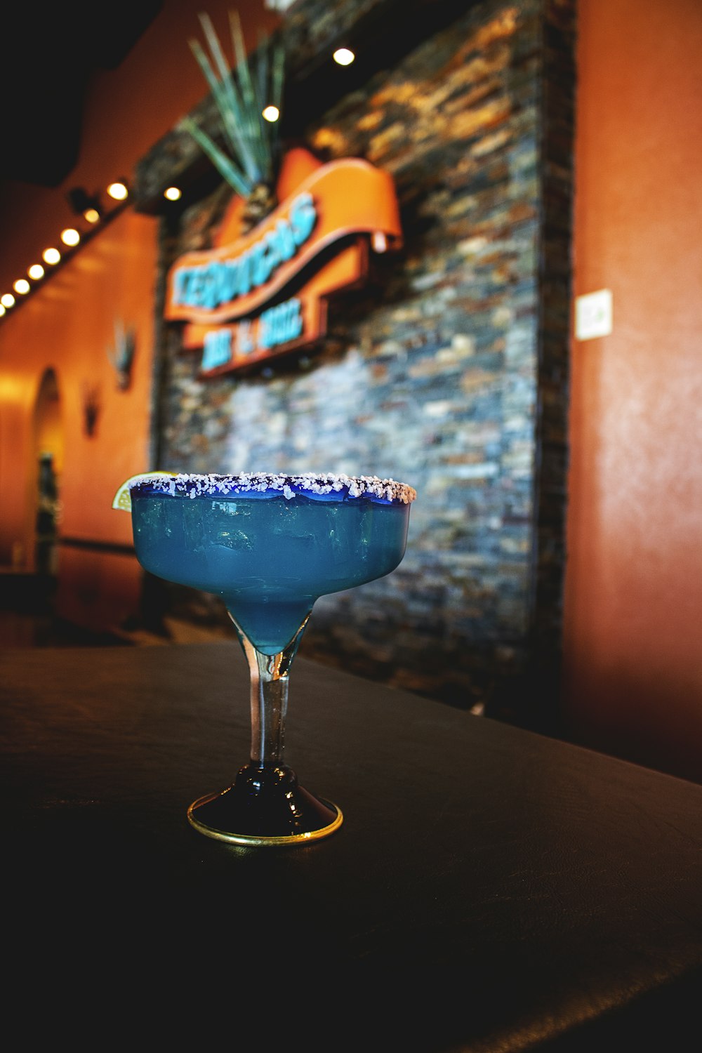 glass of blue margarita on table