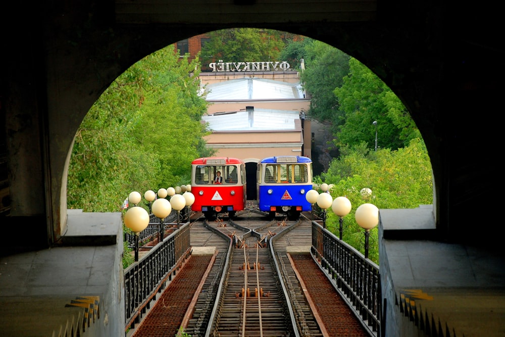 파란색과 빨간색 열차 두 대가 나란히 주차되어 있습니다.