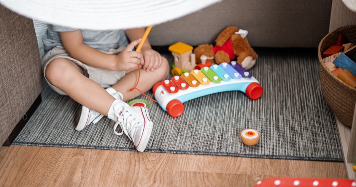 Baby sitting on the floor playing with colourful toys