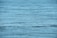 Calm and expansive body of water with gentle ripples across the surface, reflecting a serene blue hue.