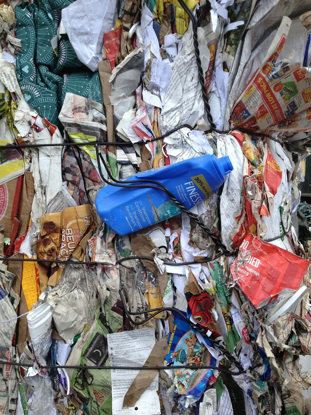 Botella de plástico azul encima de la basura