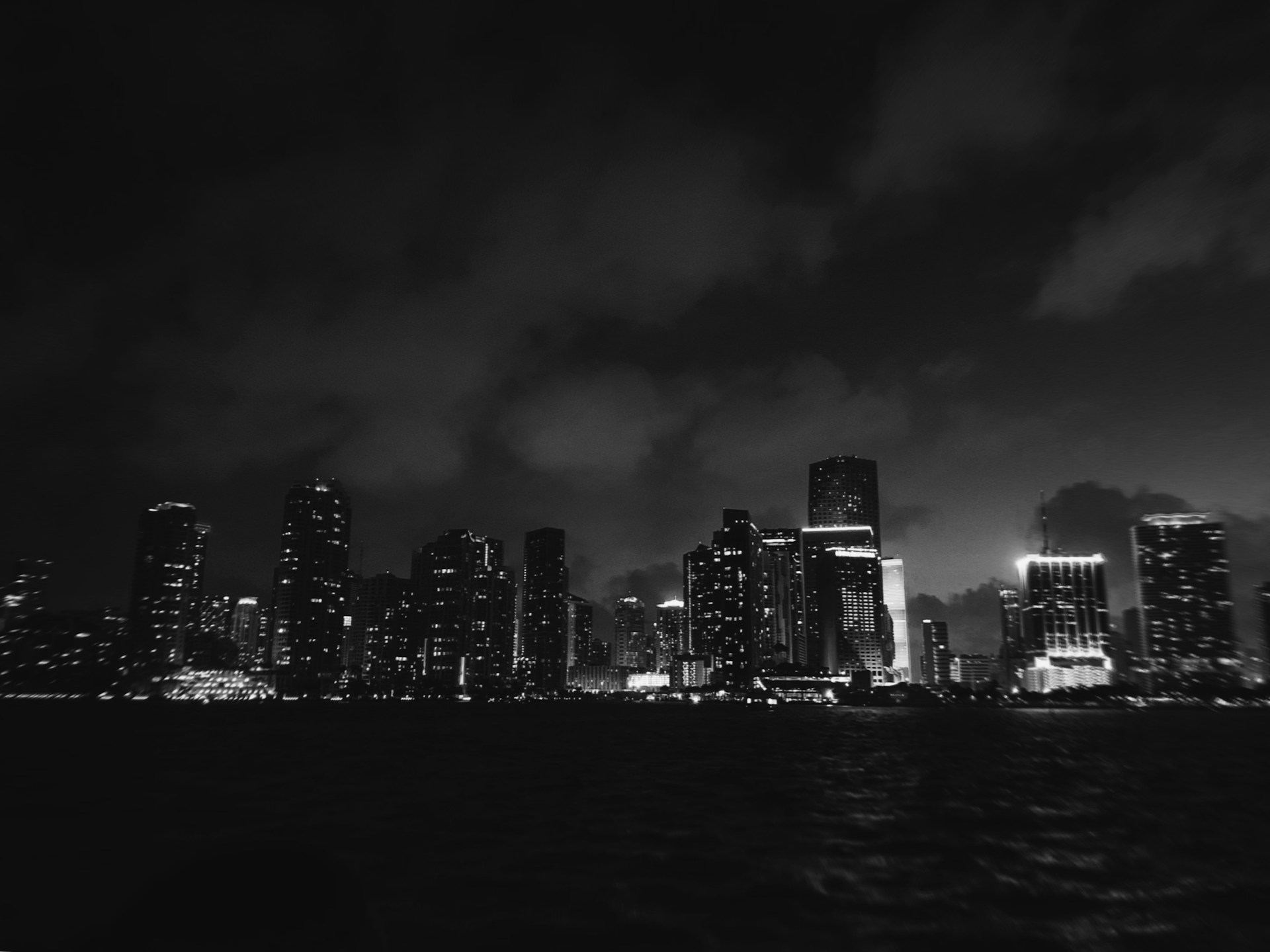 grey cloudy sky over the city by the harbor at nighttime