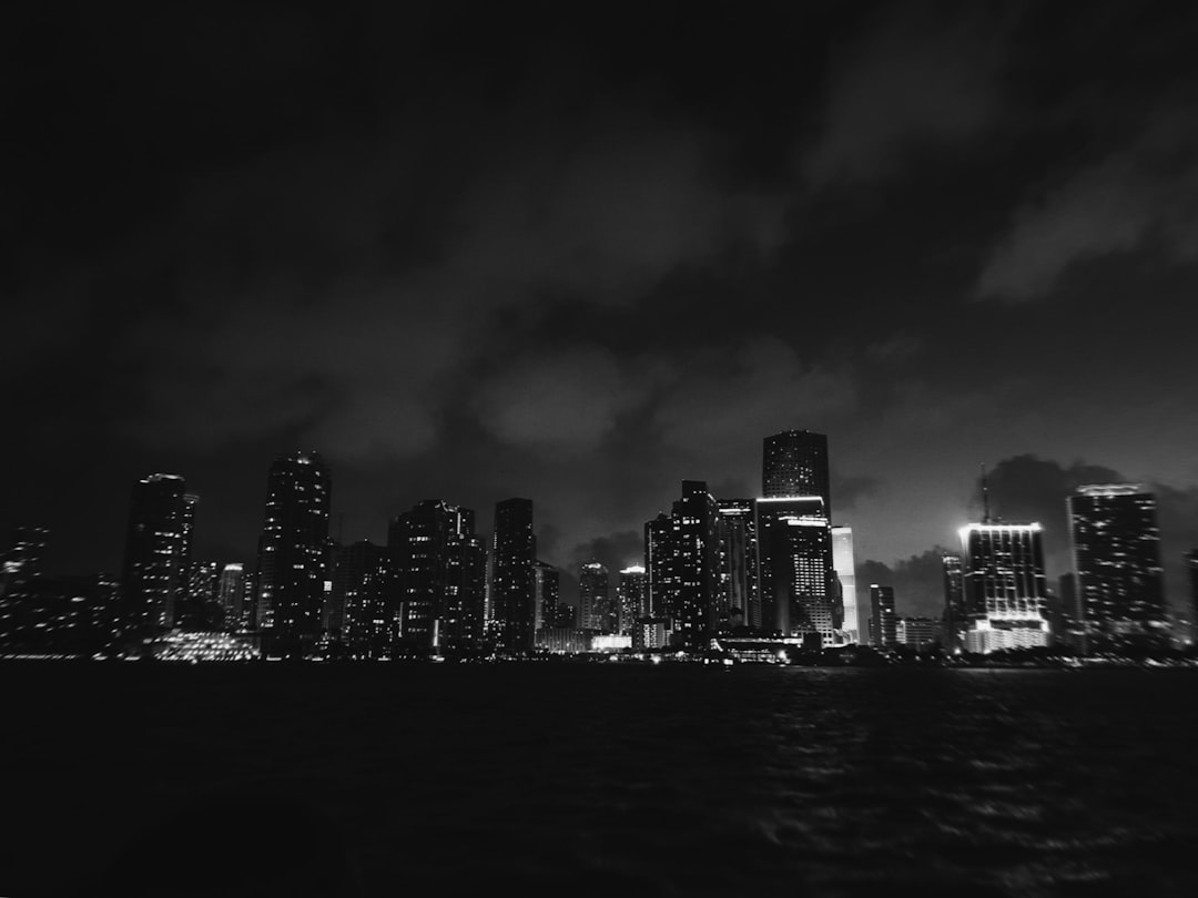 grey cloudy sky over the city by the harbor at nighttime,