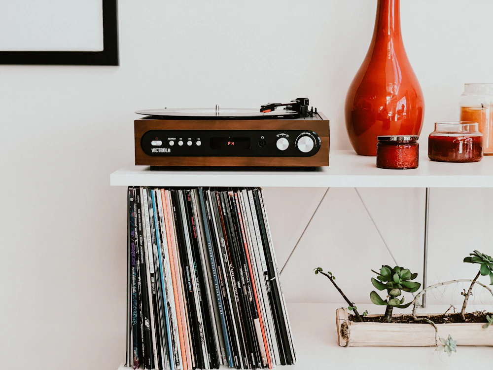 Turntable on a shelf above a row of vinyl records