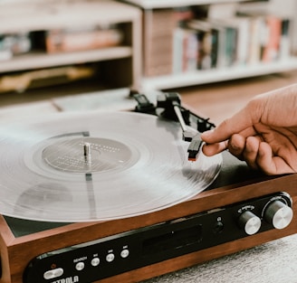 person playing record on Victrola turntable