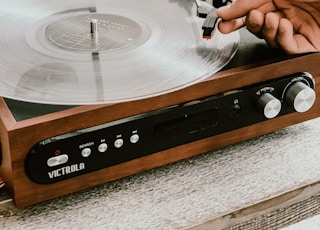 person playing record on Victrola turntable