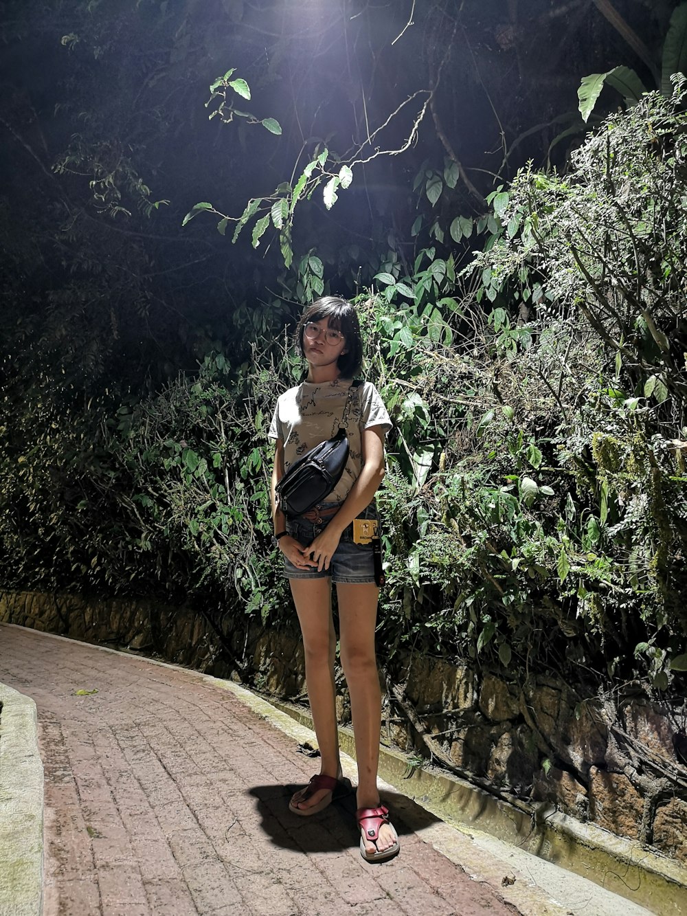 woman standing beside hedges