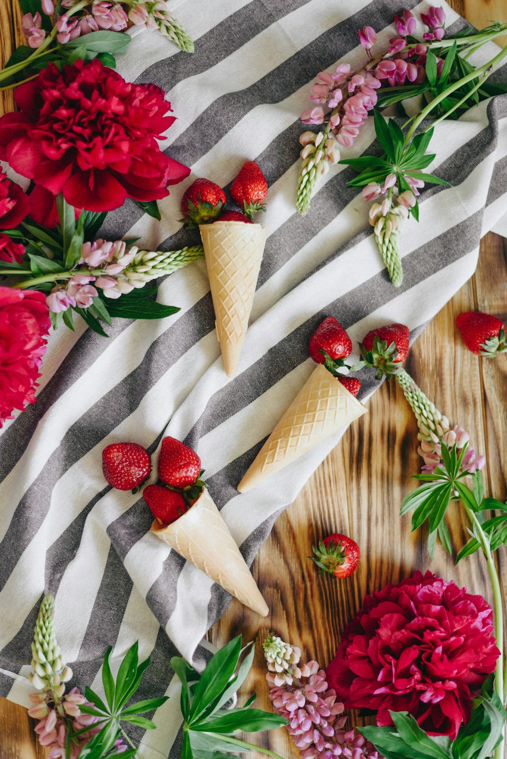 strawberries flowers and cones on table