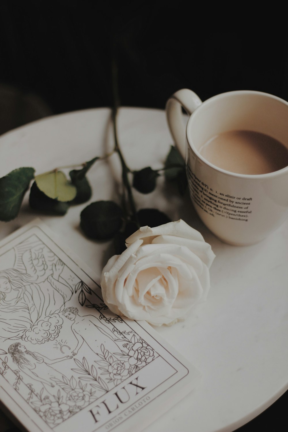 white rose flower beside white mug