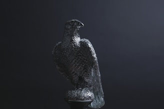 Elegant sculpture of a condor in flight, set against a dark gallery background.