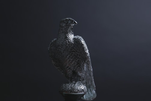 Elegant sculpture of a condor in flight, set against a dark gallery background.