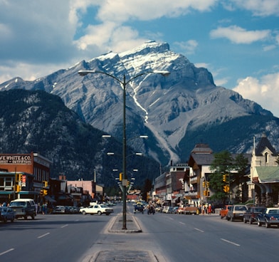 cars parked beside road near mountain