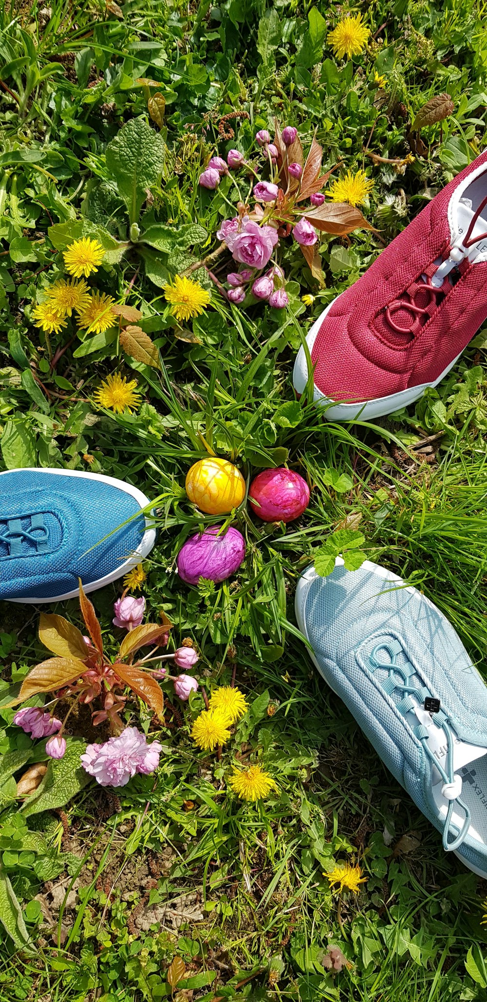 tre scarpe di colori assortiti vicino alle uova di Pasqua in campo verde