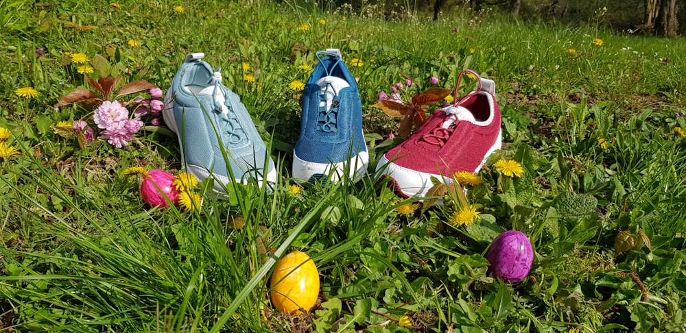 three assorted-color sneakers on grass