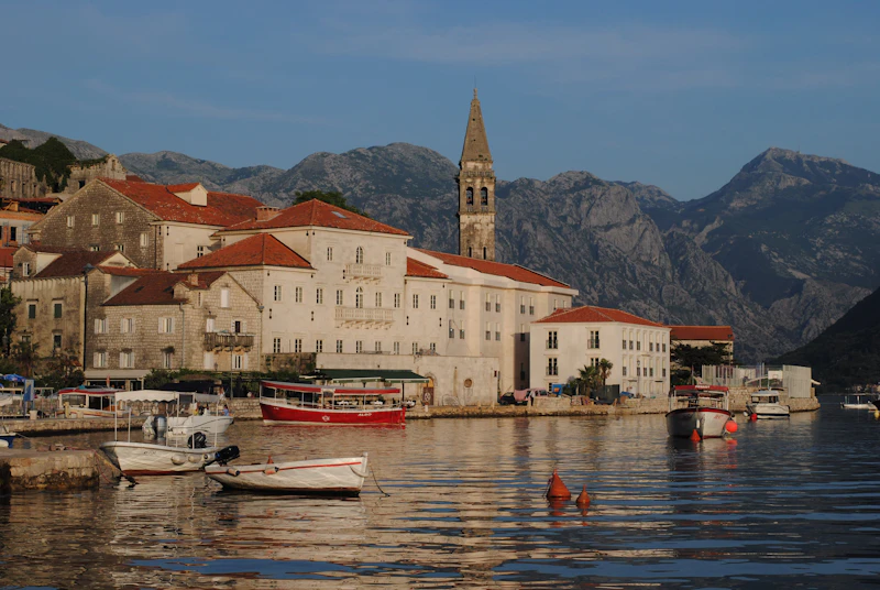 The baroque waterfront of Perast on the Bay of Kotor, with boats and a church belltower