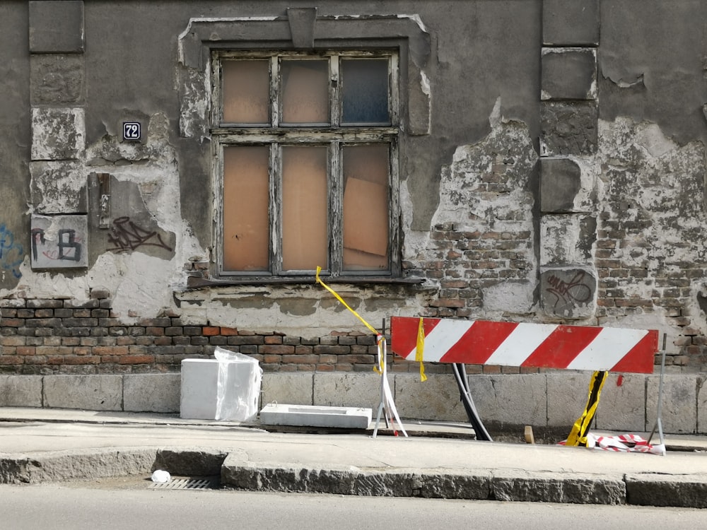 brown concrete building with boarded up windows