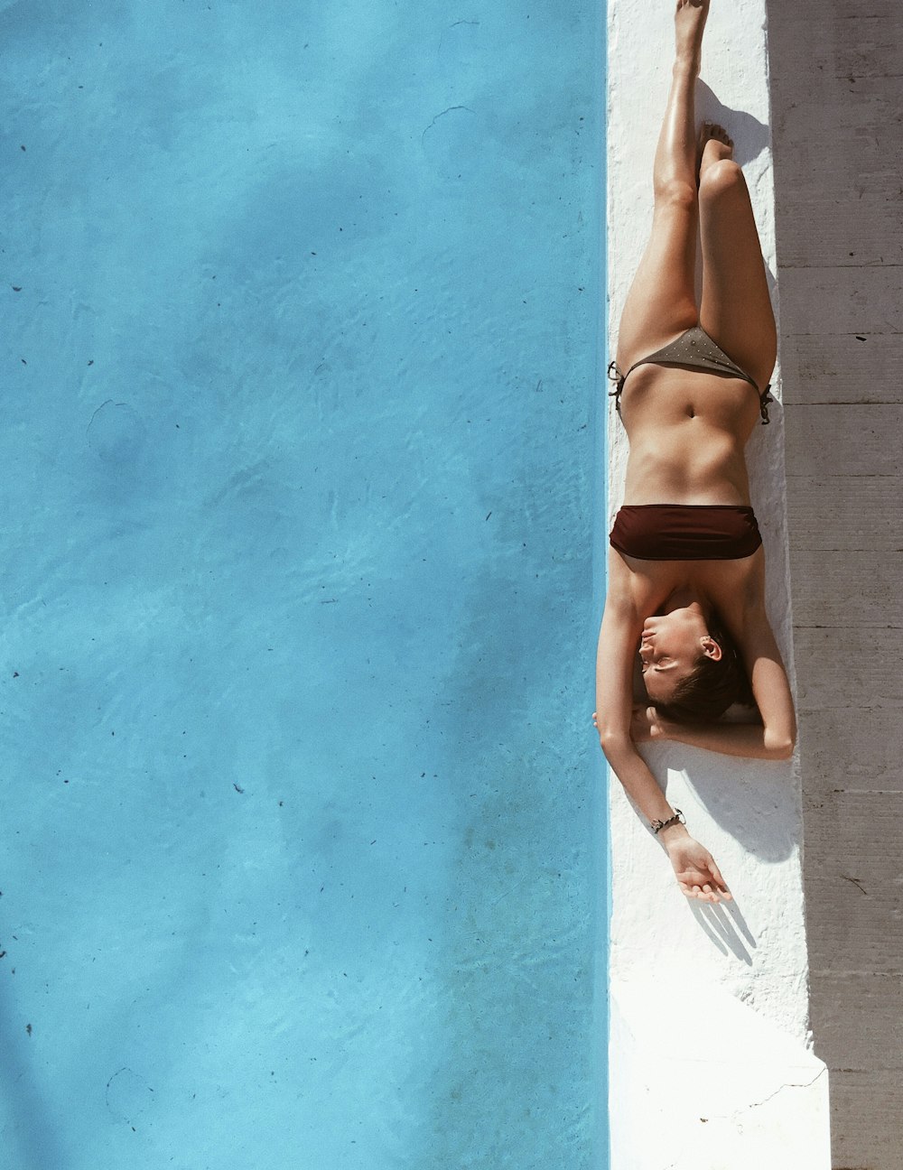 woman sunbathing beside pool