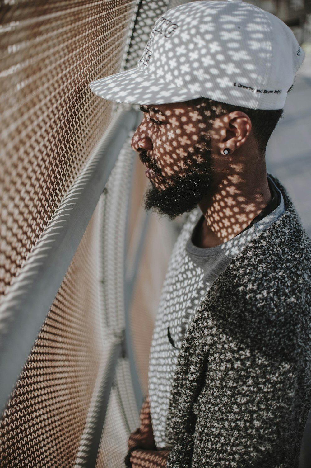 man facing white screen fence