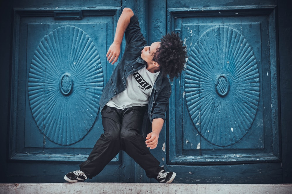 Uomo che fa acrobazia davanti alla porta blu