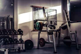 A personal training studio with weightlifting equipment including dumbbells, barbells, and a squat r