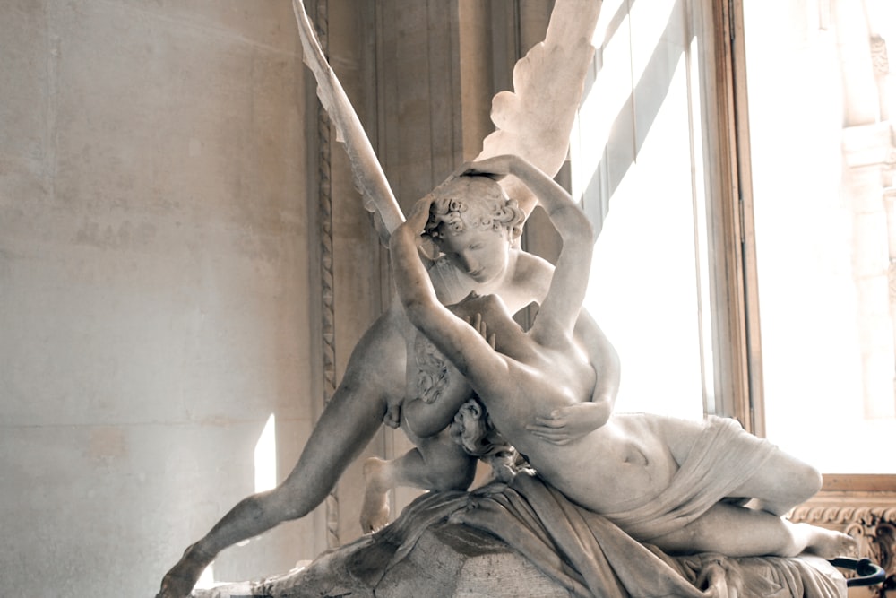 donna e angelo che baciano la statua