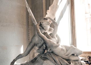 woman and angel kissing statue