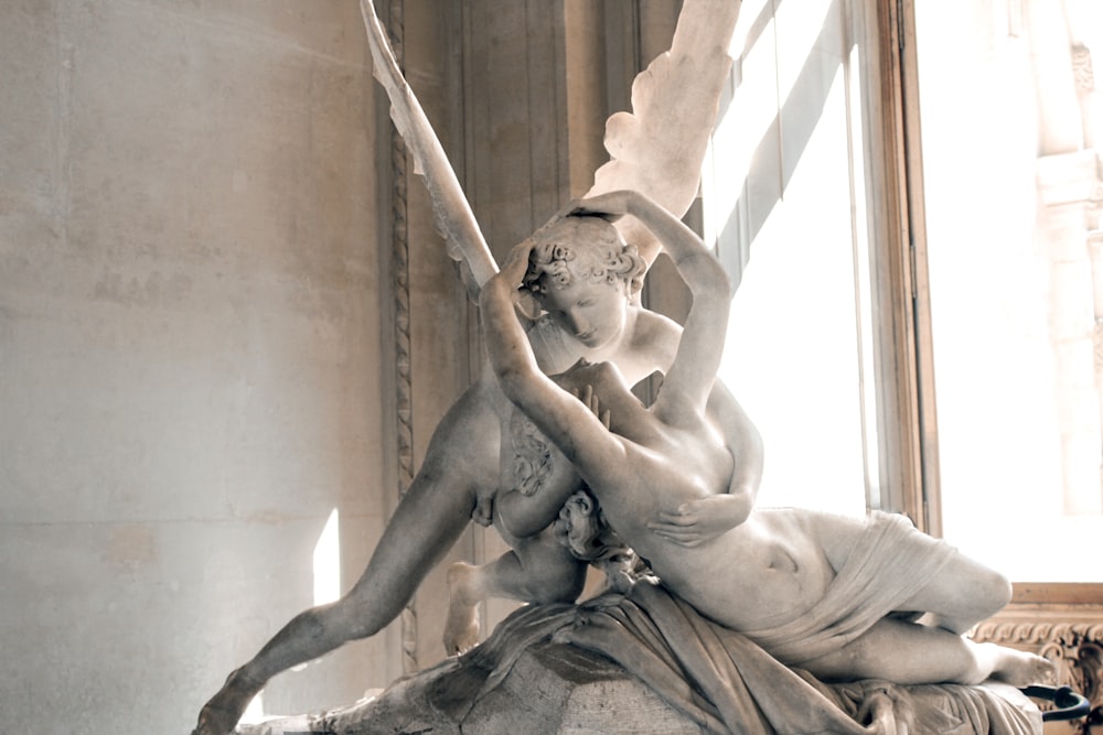 woman and angel kissing statue