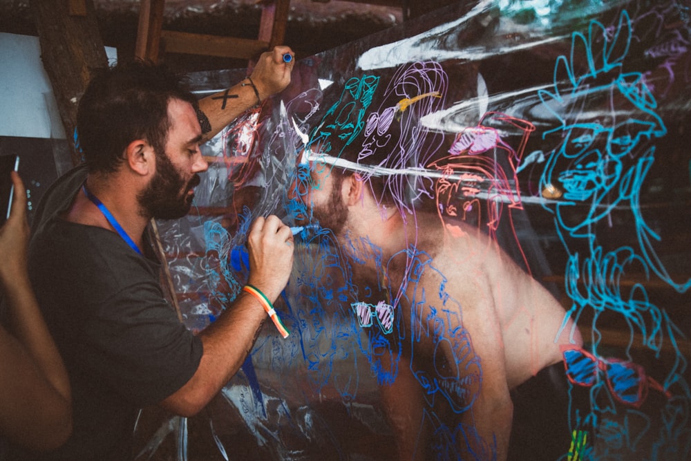 man making graffiti in front of person