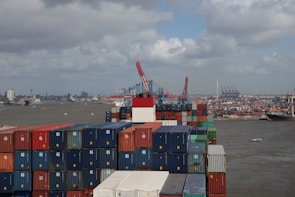 Cargo containers stacked at a busy international shipping port.