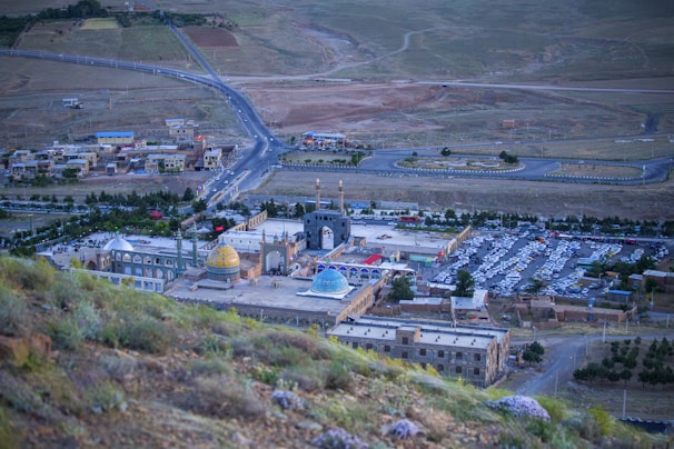 An aerial view showing a dome-enclosed small city surrounded by rugged terrain.