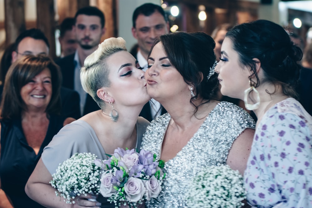 woman kissing the cheek of the bride at the ceremony