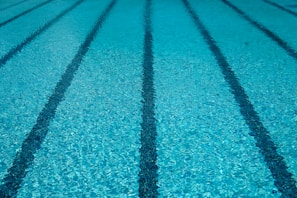 A sparkling clean commercial pool with clear blue water and neatly maintained surroundings.