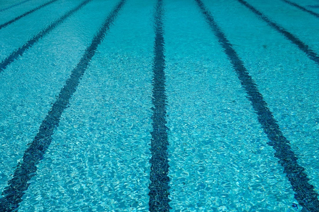 Striped lines beneath clear cold blue swimming pool water during the summer ready for a swim