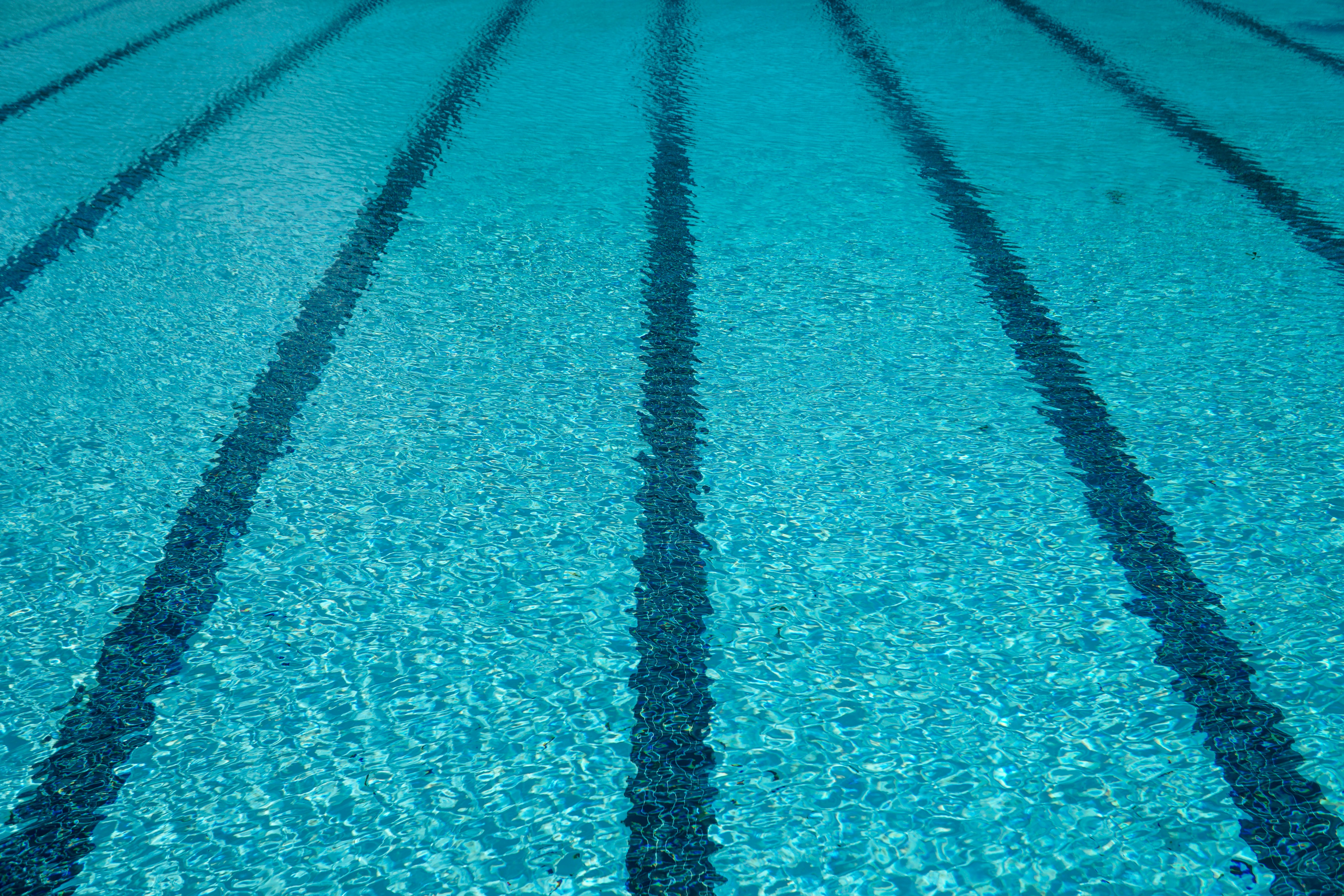 Striped lines beneath clear cold blue swimming pool water during the summer ready for a swim