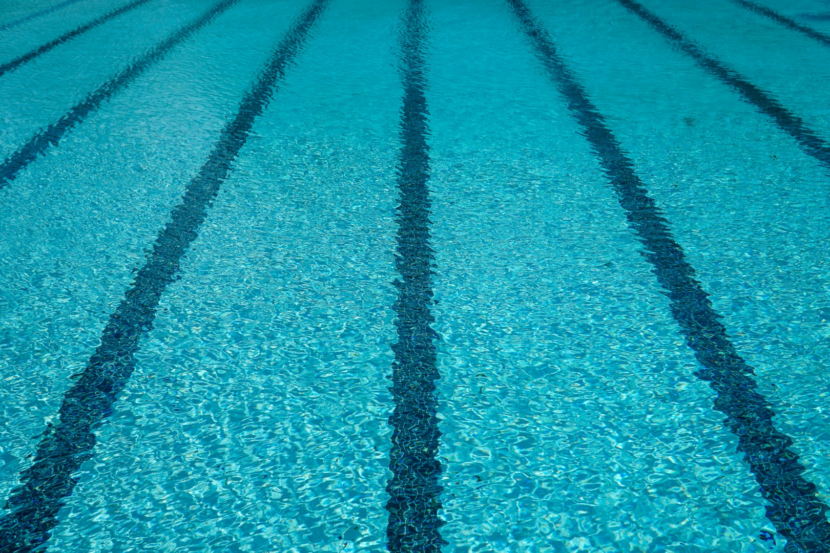 Cordless robotic pool cleaner gliding through crystal-clear blue pool water