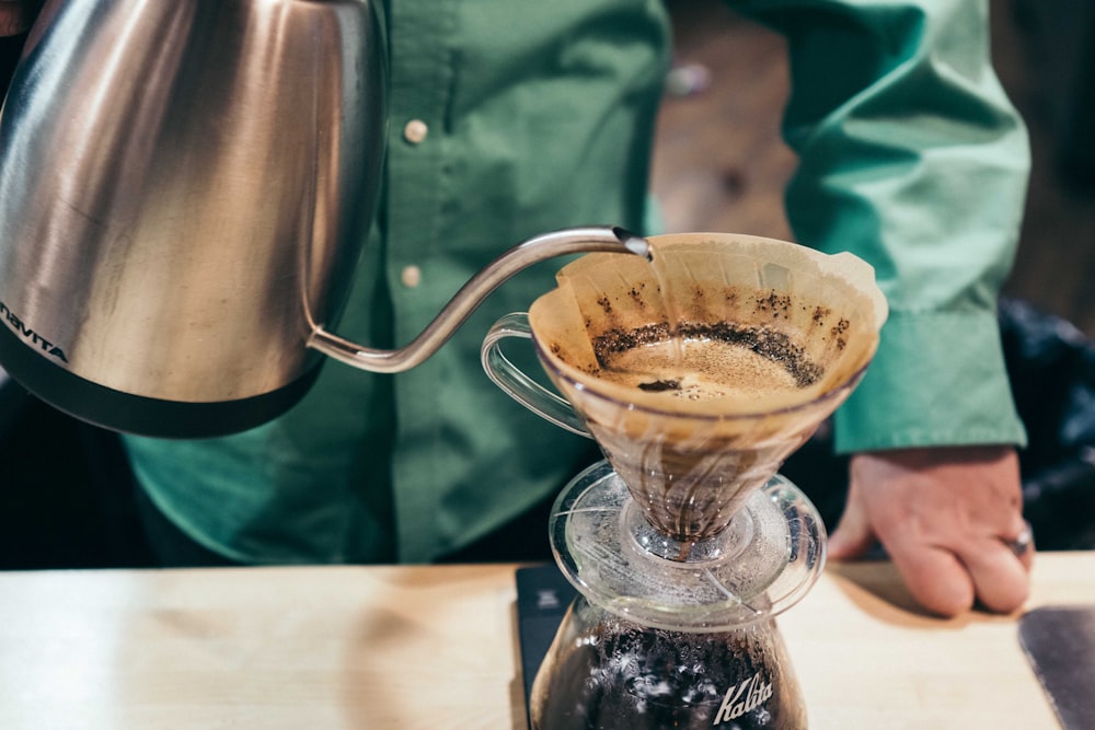 person holding gray and black kettle