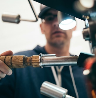 man wearing black pullover hoodie holding tool