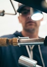 man wearing black pullover hoodie holding tool