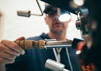 man wearing black pullover hoodie holding tool