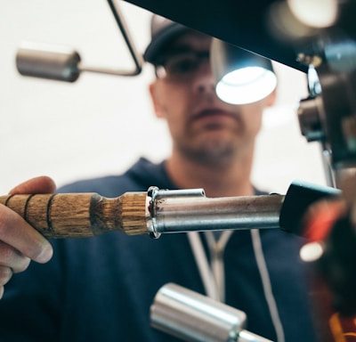 man wearing black pullover hoodie holding tool