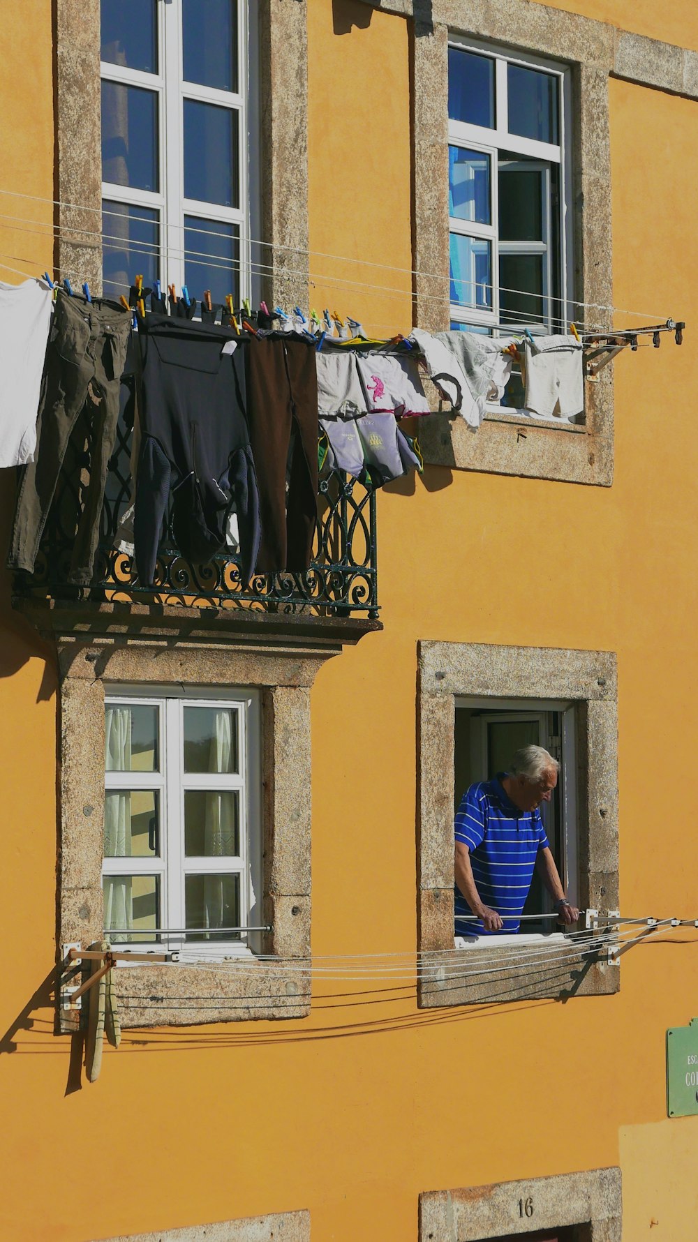 assorted clothes hanging beside yellow house
