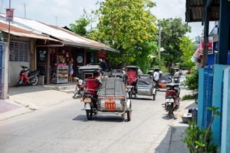A vibrant shot of a canvolt electric tricycle cruising through a bustling Ethiopian market street under a clear blue sky.