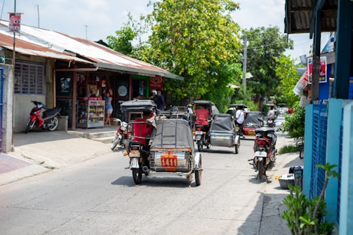 A vibrant shot of a canvolt electric tricycle cruising through a bustling Ethiopian market street under a clear blue sky.