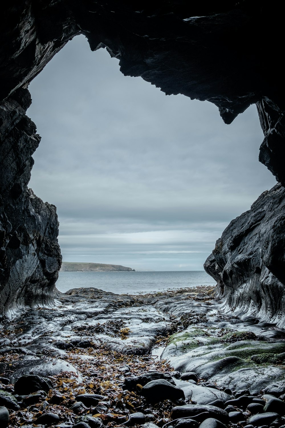 Formação rochosa cinzenta ao lado da praia
