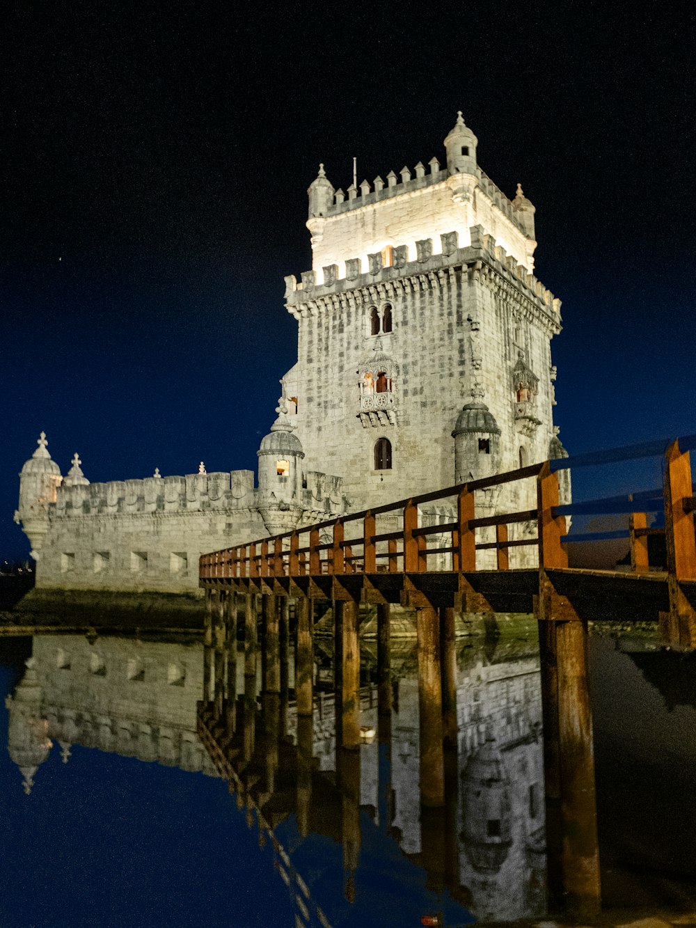 una grande torre bianca seduta accanto a uno specchio d'acqua