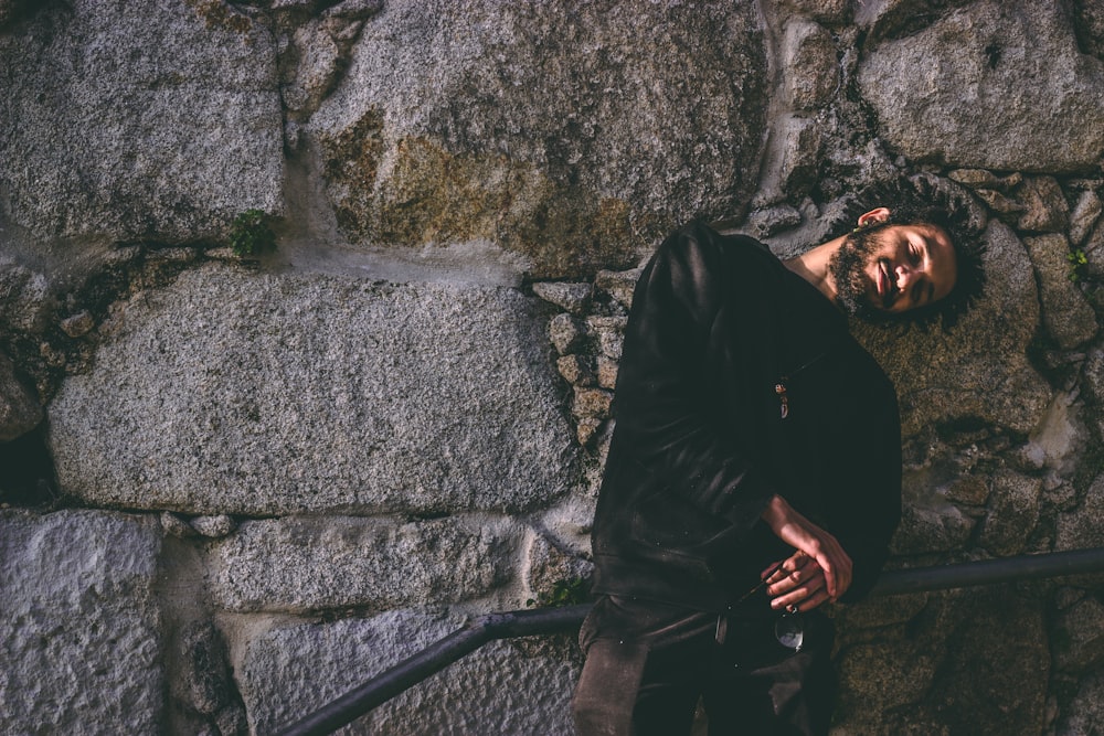 man leaning on wall